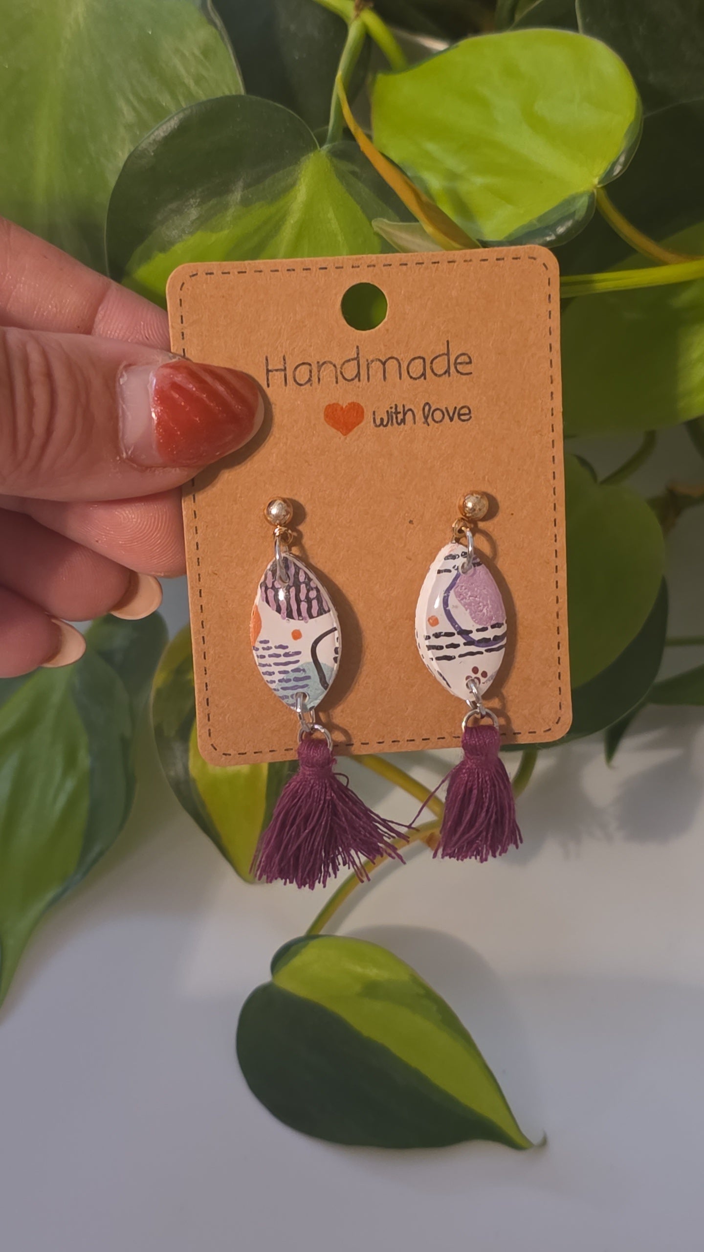 Gold geometric shaped earrings with purple tassles
